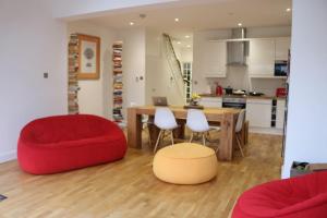 a living room with a table and a red chair at Home in Streatham in Streatham Vale