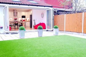 a patio with potted plants on a lawn at Home in Streatham in Streatham Vale