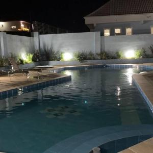 una piscina en una casa por la noche en POUSADA BLUE GARDEN en Lages