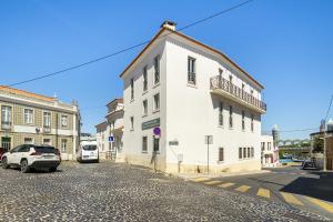 ein weißes Gebäude an der Straßenseite in der Unterkunft WHome Urban Comfort: 1-BR near Airport & Train Station in Lissabon