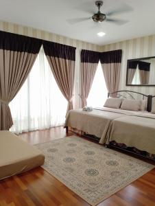 a bedroom with two beds and large windows at Juniper Homestay Putrajaya Presint 11 in Putrajaya
