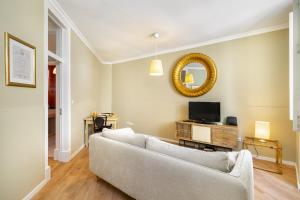 - un salon avec un canapé blanc et un miroir dans l'établissement WHome Urban Comfort: 1-BR near Airport & Train Station, à Lisbonne