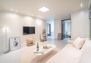 un salon avec un canapé blanc et une table dans l'établissement Osondoson Stay-5min to Hapjeong Station, family favorites, 3bed room, large living room, à Séoul