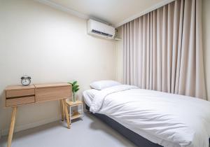une petite chambre avec un lit et un bureau dans l'établissement Osondoson Stay-5min to Hapjeong Station, family favorites, 3bed room, large living room, à Séoul