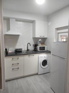 a kitchen with a washing machine and a microwave at Apartamento en Toledo ideal para visitas a Puy du Fou in Toledo