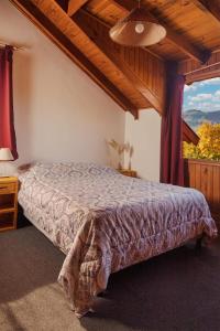 1 dormitorio con cama y ventana grande en Casa Hostel - Paseo del Sol en San Martín de los Andes