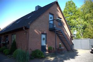 a red brick house with a spiral staircase at Ferienwohnung Allegra in Süderlügum