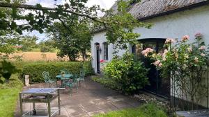 a patio with chairs and a table in front of a house at Ferienhaus Villa Vogelsang (Schlei / Ostsee) in Stoltebüll