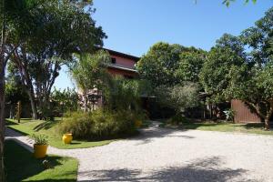 a house with trees and a gravel driveway at Morada Alto Astral in Imbituba