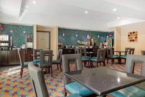 a restaurant with tables and chairs and a bar at Best Western Plus Pleasanton Hotel in Pleasanton