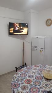 Habitación con mesa y TV en la pared. en La Nona en Villa Cura Brochero