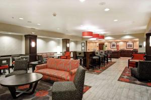 a hotel lobby with a couch and tables and chairs at Hampton Inn Middletown in Middletown