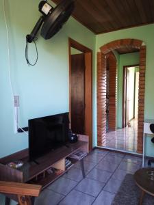 a living room with a flat screen tv at Hospedaria das Azaleias in Novo Hamburgo