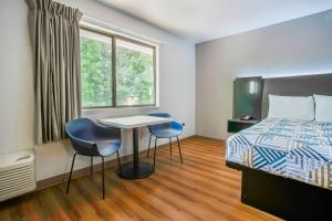 a hotel room with a bed and a table and chairs at Motel 6-Gresham, OR - Portland in Gresham