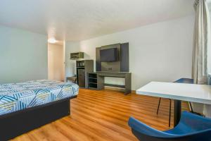 a bedroom with a bed and a desk and a television at Motel 6-Gresham, OR - Portland in Gresham