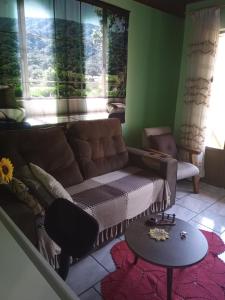 a living room with a couch and a table at Hospedaria das Azaleias in Novo Hamburgo