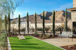 a bench in a garden with trees and grass at Homewood Suites By Hilton Santa Clarita/Valencia, Ca in Santa Clarita