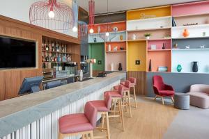 un bar en un restaurante con sillas rojas en Hampton By Hilton Barcelona Fira Gran Via, en Hospitalet de Llobregat