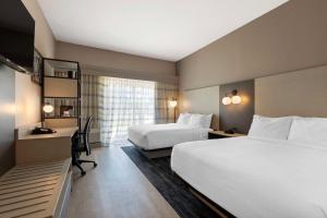 ein Hotelzimmer mit 2 Betten und einem Schreibtisch in der Unterkunft Best Western Plus Fort Worth North in Fort Worth