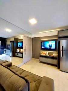 a living room with a couch and a flat screen tv at Estúdio Completo e Aconchegante no Ed. Vertigo in Campo Grande