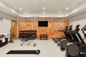 a gym with cardio equipment and a wall of wine bottles at The Eddy Hotel Tucson, Tapestry Collection By Hilton in Tucson