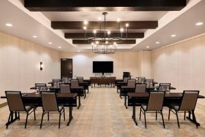 a conference room with tables and chairs and a projection screen at The Eddy Hotel Tucson, Tapestry Collection By Hilton in Tucson