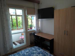 a bedroom with a desk and a bed and a window at Apartament Promenada, 3 camere, max 6 persoane, locatie ideala, 10 min de mers pana la plaja in Constanţa