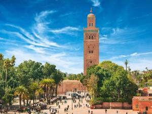 una torre dell'orologio con una folla di persone davanti di DAR ESSHRA a Marrakech