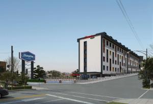 a large white building on the side of a street at Hampton By Hilton Istanbul Airport, Arnavutkoy in Istanbul