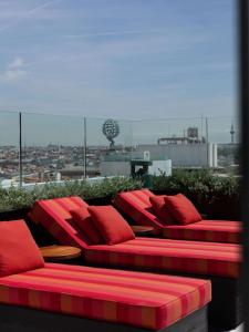 a red couch with red pillows on top of a building at Hotel Montera Madrid, Curio Collection By Hilton in Madrid