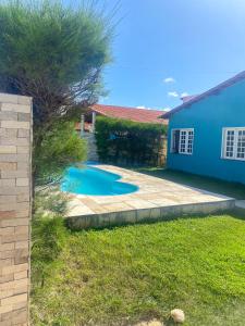 a backyard with a blue house and a swimming pool at Casa Rústica em Morro Branco - na quadra da praia in #N/A