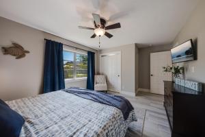 een slaapkamer met een bed en een plafondventilator bij Baydream Bungalow 3472 in Siesta Key