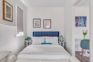 um quarto branco com uma cama azul em Lake Cottage Getaway em Portland