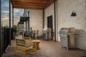 een patio met 2 stoelen, een grill en een tafel bij Home2 Suites By Hilton Flower Mound Dallas in Flower Mound