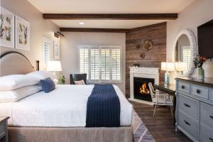 希尔兹堡The Lodge at Healdsburg, Tapestry Collection by Hilton的带一张大床和一个壁炉的卧室