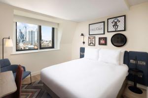 een slaapkamer met een groot wit bed en een raam bij Hampton By Hilton London City in Londen