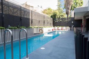 een zwembad met een hek en blauw water bij Ola Santiago Providencia, Tapestry Collection by Hilton in Santiago