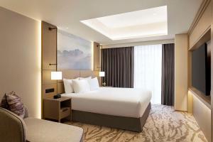 Rúm í herbergi á DoubleTree by Hilton Toyama