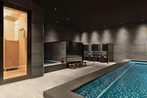 a swimming pool with two lounges and a swimming pool at DoubleTree by Hilton Toyama in Toyama