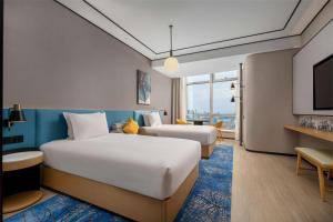 una camera d'albergo con due letti e una televisione di Hilton Garden Inn Shanghai Lujiazui a Shanghai