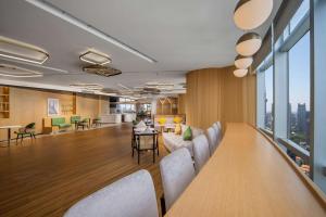 um átrio de escritório com uma mesa longa e cadeiras em Hilton Garden Inn Shanghai Lujiazui em Xangai