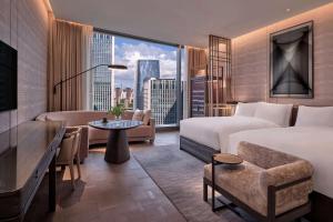 um quarto de hotel com uma cama e uma secretária em Conrad Shenzhen, Complimentary mini-bar for first round em Shenzhen