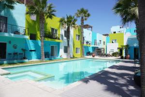a swimming pool in the courtyard of a building with palm trees at Ocean View 15 Gardenhaus in Tijuana