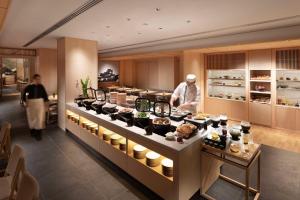 a chef preparing food in a restaurant kitchen at DoubleTree by Hilton Kyoto Higashiyama in Kyoto