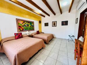 a bedroom with two beds in a room at Los Arrayanes in Oaxaca City