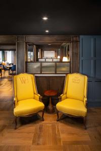 two yellow chairs in a room with a bar at Wylie Hotel Atlanta, Tapestry Collection by Hilton in Atlanta