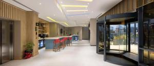 a lobby of a building with a bar with red stools at Hampton By Hilton Cerkezkoy in Tekirdag