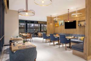 een restaurant met tafels en stoelen en een tv bij Hampton By Hilton Cerkezkoy in Tekirdag
