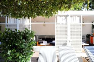 eine Terrasse mit zwei weißen Stühlen und einem Baum in der Unterkunft Nautilus Sonesta Miami Beach in Miami Beach