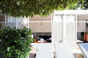 a patio with two white chairs and a tree at Nautilus Sonesta Miami Beach in Miami Beach